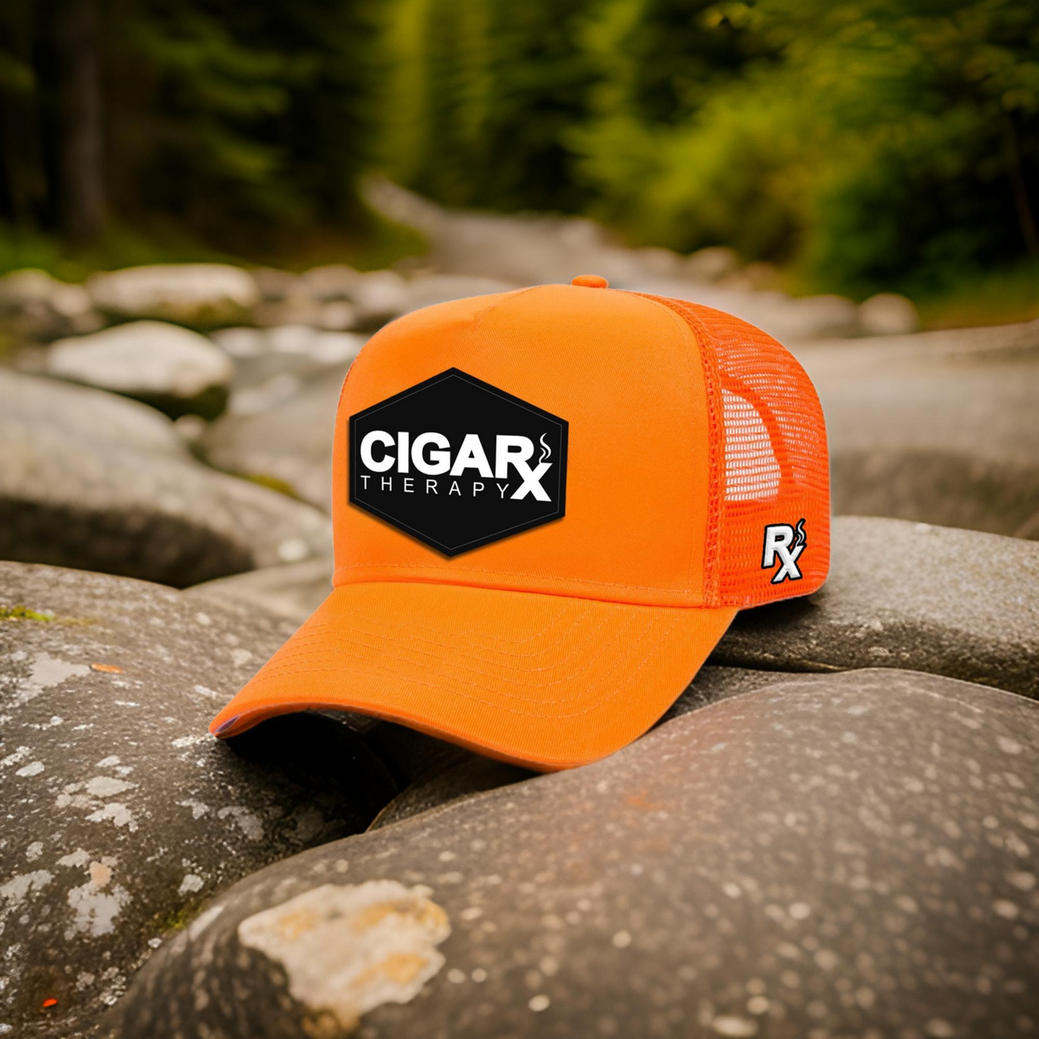 Orange cap with 'Cigar Therapy' logo on a rock with a natural background